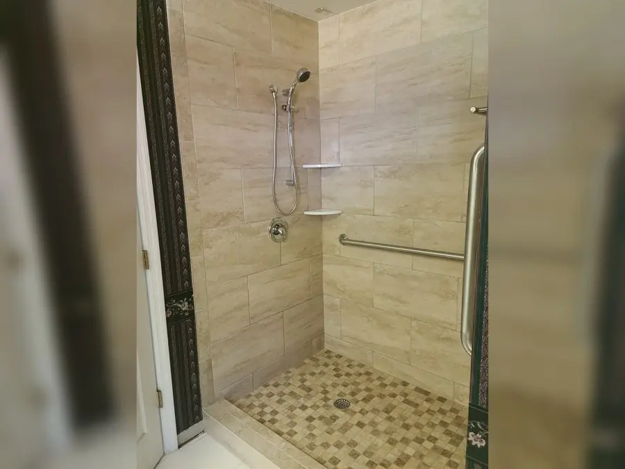 Tiled walk-in shower with a grab bar